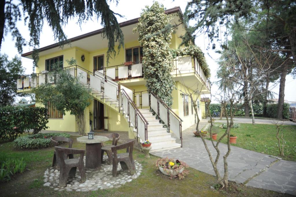 una casa gialla con tavolo e sedie nel cortile di Agostini Daniela B&B a Cadoneghe
