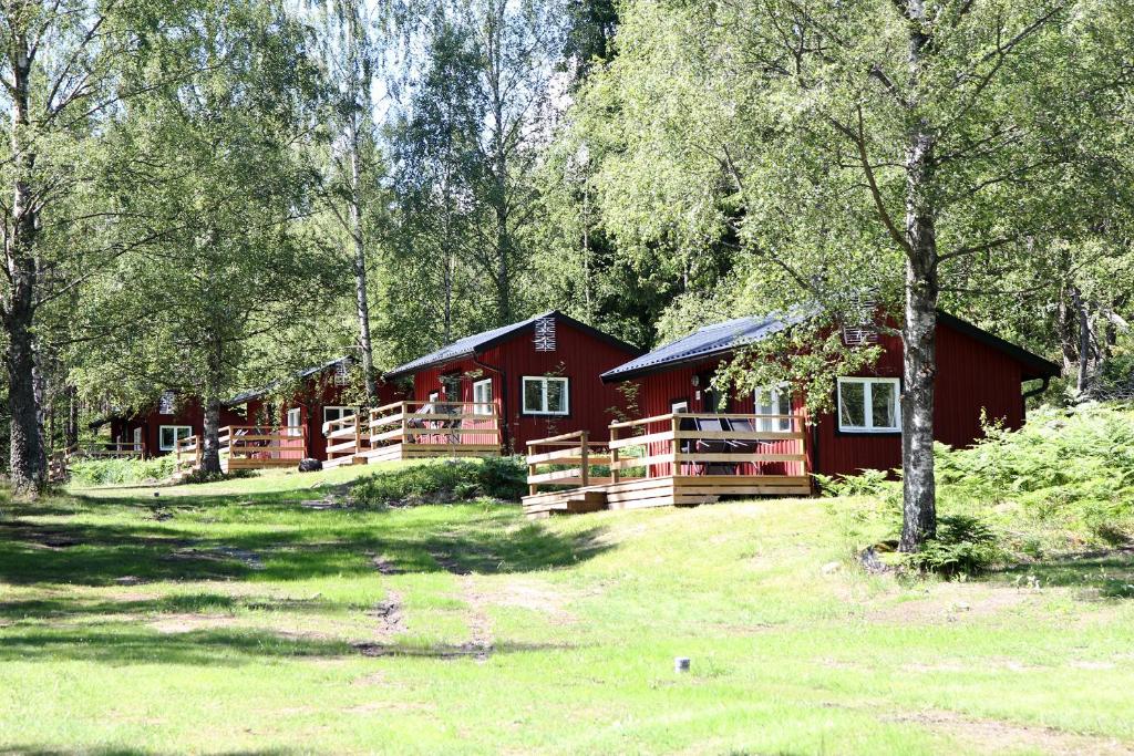 a red cabin in the middle of a forest at Gålö Havsbad - Holiday Cottages and Hostel in Gålö