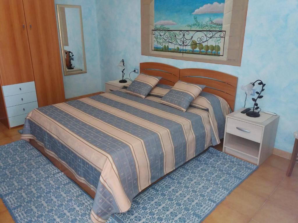 a bedroom with a large bed with a wooden headboard at Rita b&b sea sun and nature in Santa Maria la Palma