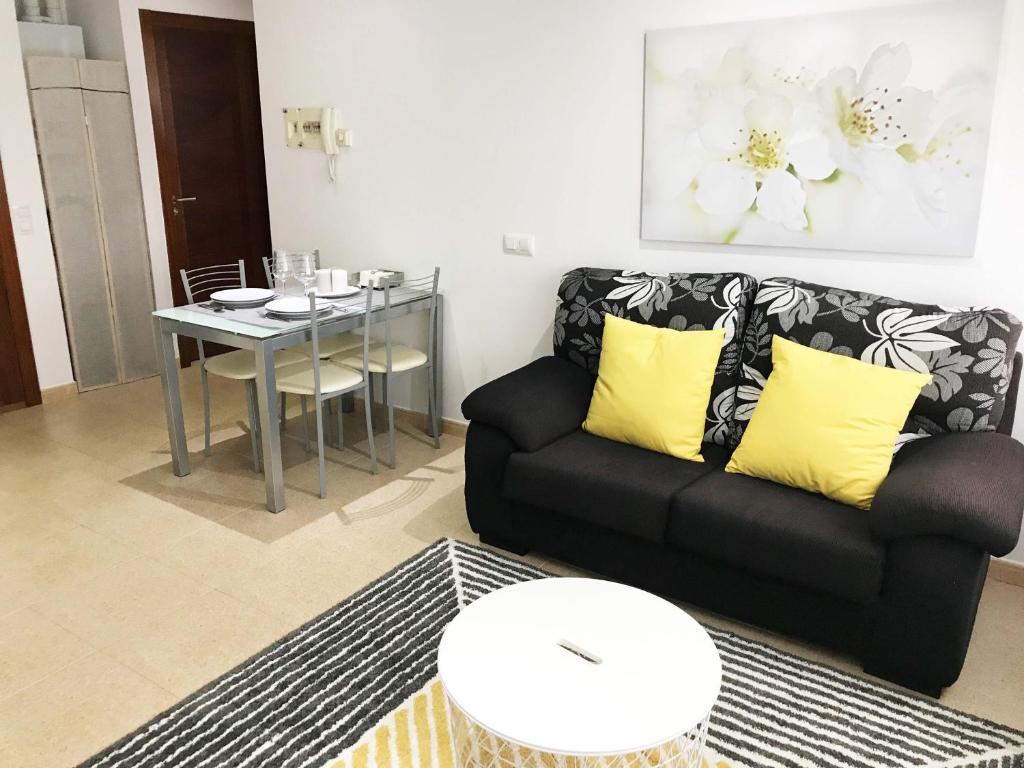 a living room with a black couch and a table at Apartamento San Isidoro in Santiago de Compostela