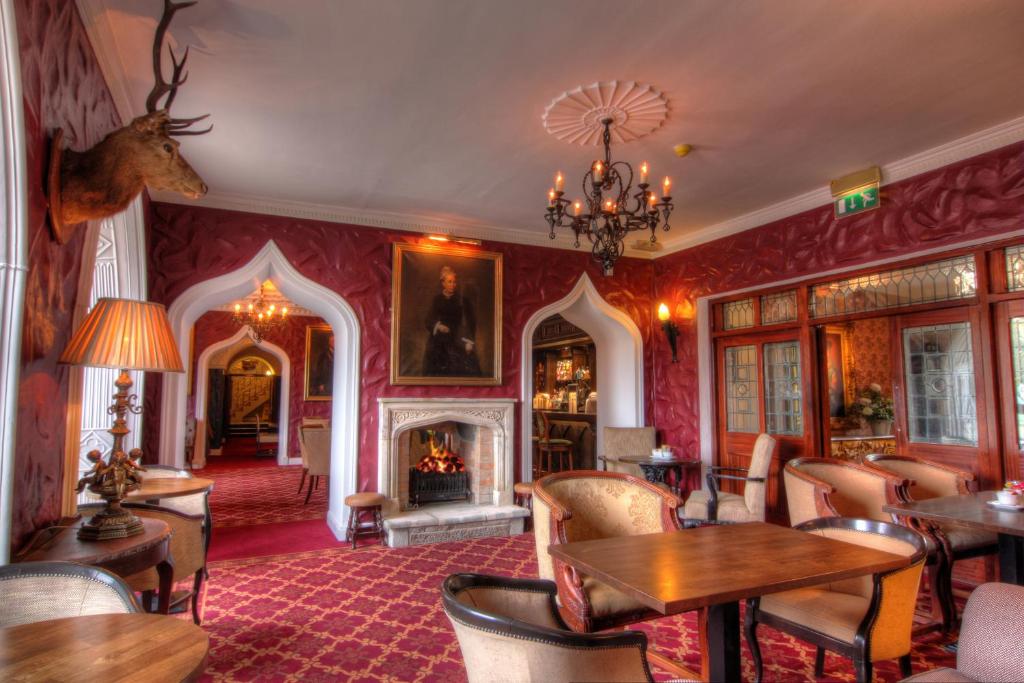 Cozy vintage lounge with fireplace, ornate decor, and plush seating.