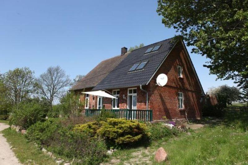 una grande casa di mattoni rossi con tetto di gambero di Ferienwohnungen im daenischen Landhausstil a Altkamp