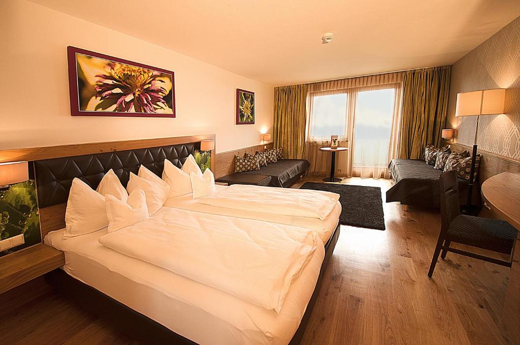um quarto com uma grande cama branca num quarto em Hotel Rettenberg em Kolsass