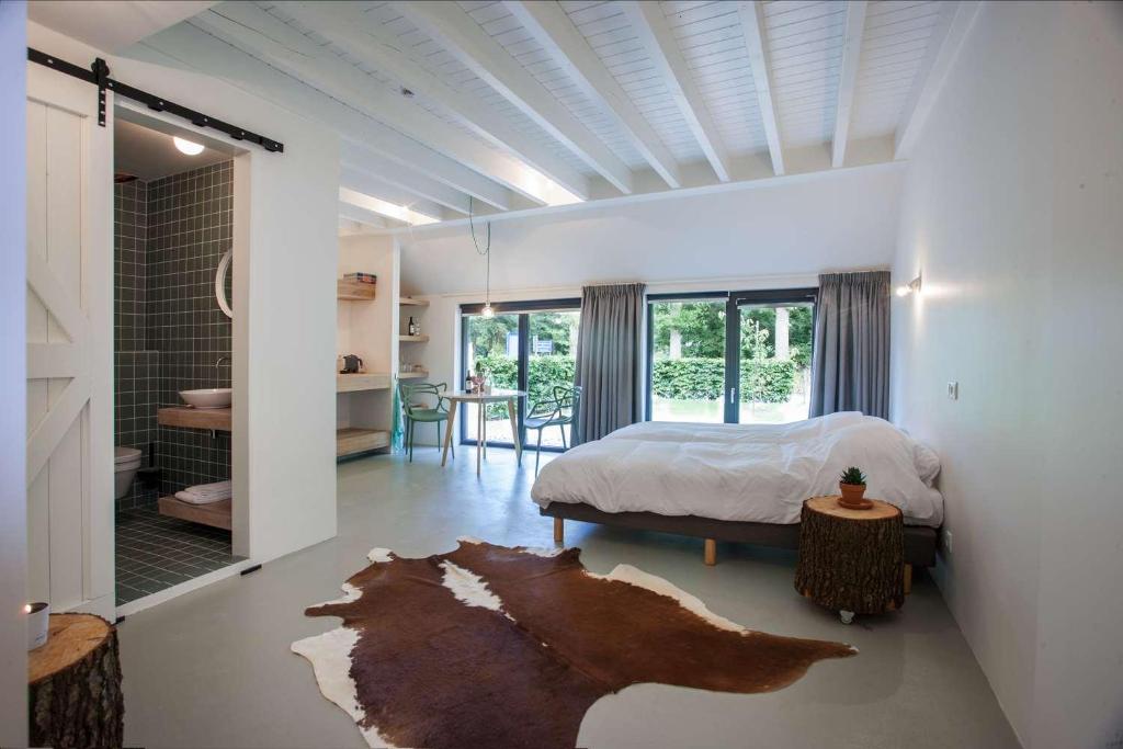 a bedroom with a bed and a room with a table at Uitgerust voor Zaken in Heerenveen