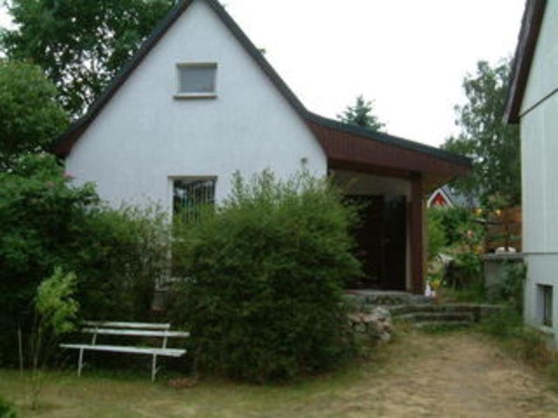 a white house with a bench in front of it at Ferienhaus ruhige Lage _ strandnah in Ueckeritz