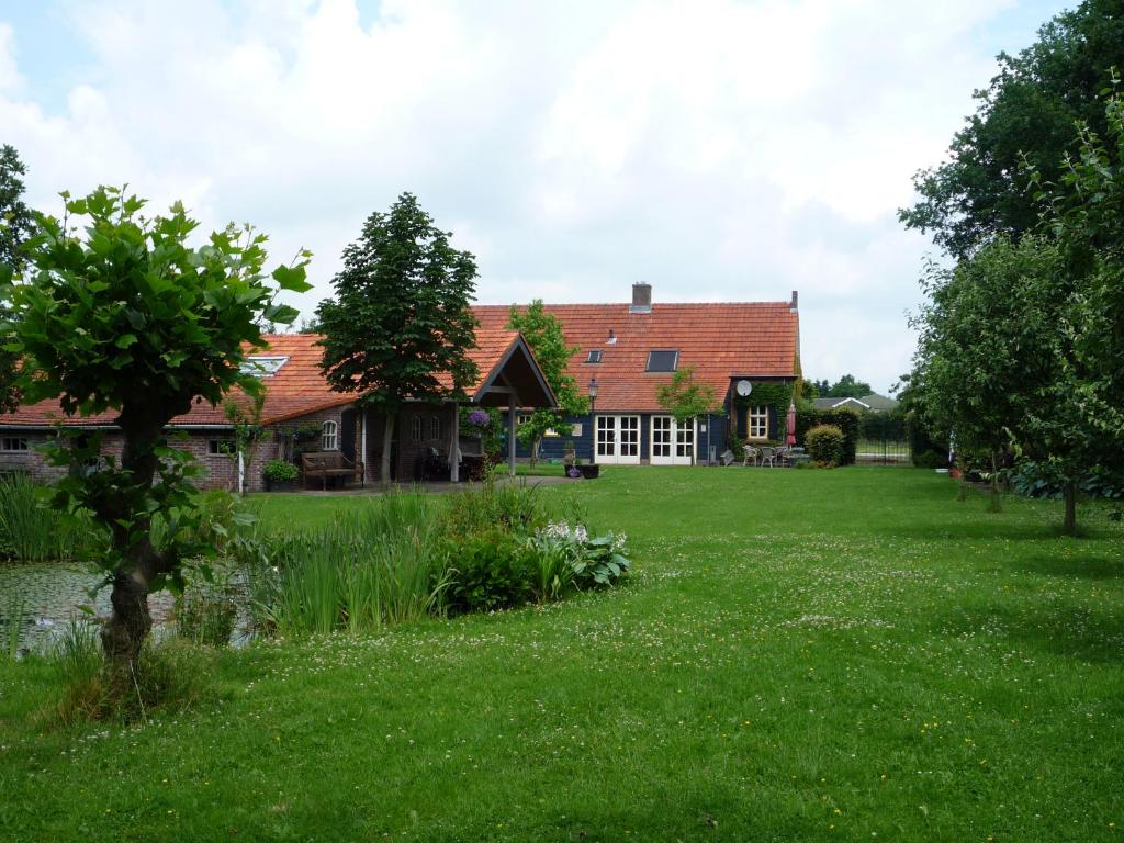 a house with a large yard in front of it at Beukenhof in Molenschot