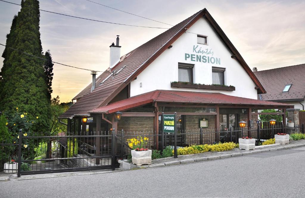 un bâtiment avec un panneau à l'avant dans l'établissement Kántás Panzió Tihany, à Tihany