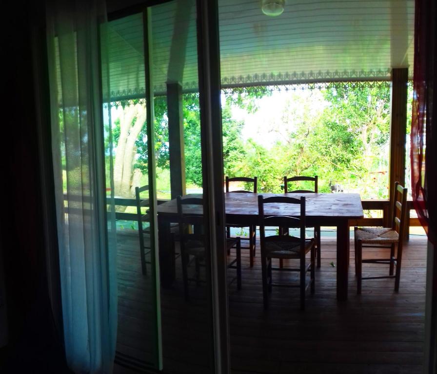 une salle à manger avec une table et des chaises sur une terrasse couverte dans l'établissement Gites de la falaise, à Le Tampon