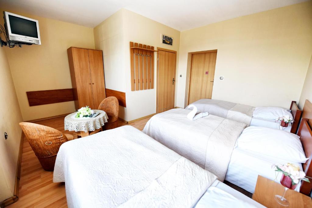 a hotel room with two beds and a table at Malibu Kalisz in Kościelna Wieś