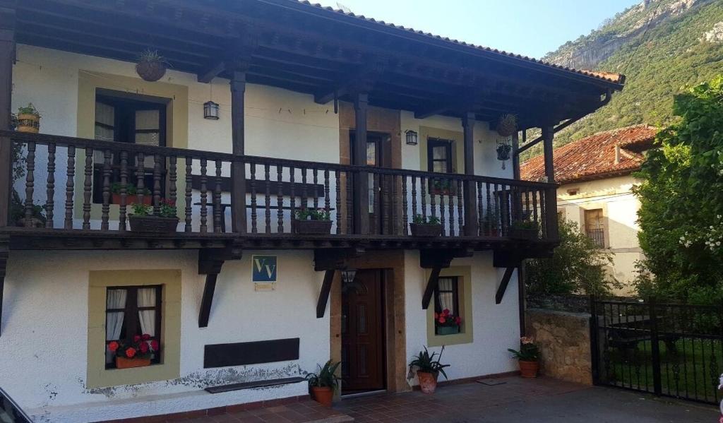 ein weißes Haus mit einem Balkon und einer Tür in der Unterkunft Casa Pelayo 2 in Poo de Cabrales