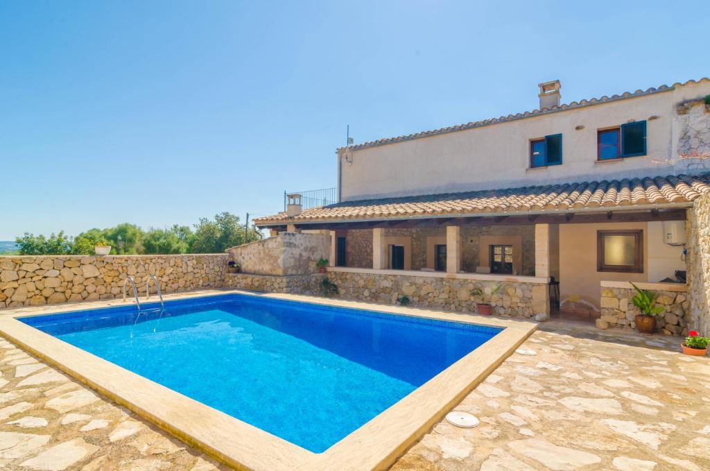 a villa with a swimming pool in front of a house at Son Ramon in Sant Joan
