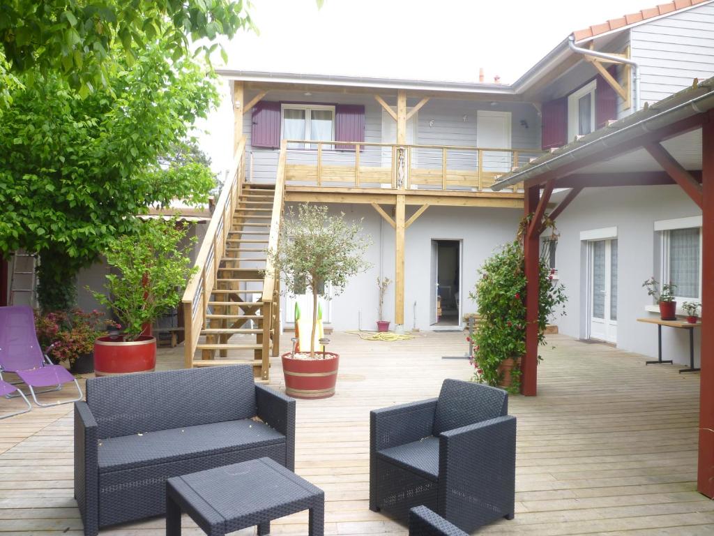 un patio con sedie e tavoli e una casa di Chez Augustin a Lacanau-Océan