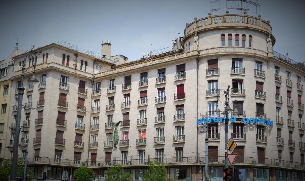 een groot wit gebouw met een blauw bord erop bij Pulse Jackquaters in Boedapest