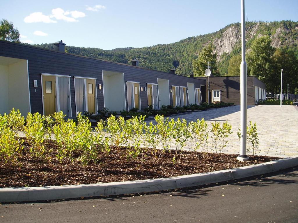 une rangée de bâtiments dans une rue avec une montagne dans l'établissement Evje Park, à Evje