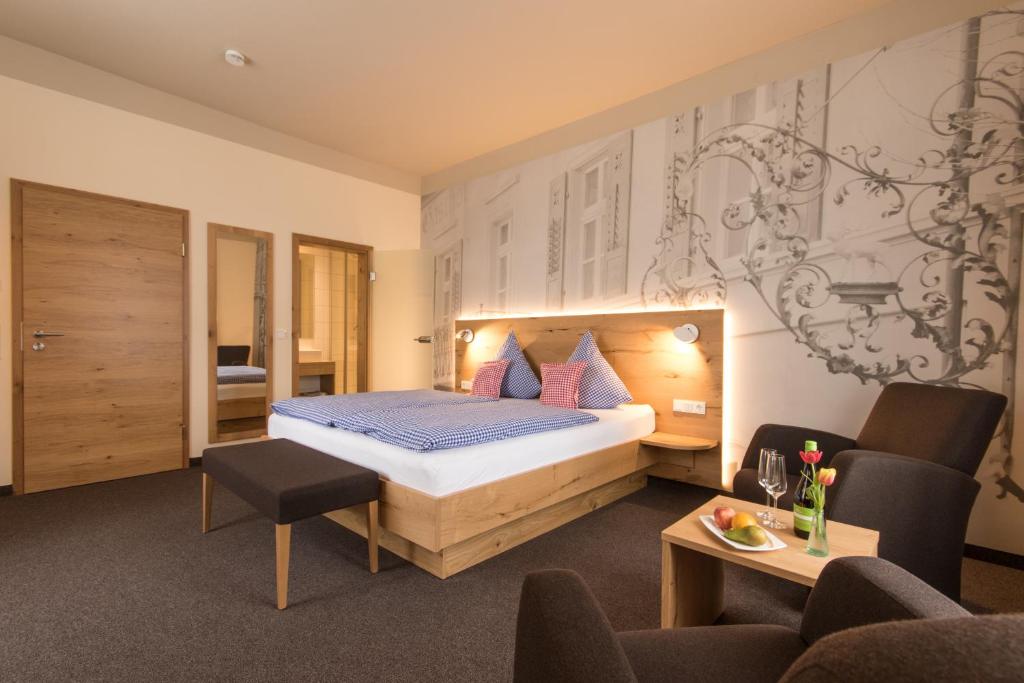 una camera d'albergo con letto, tavolo e sedie di Posthorn a Ühlingen-Birkendorf