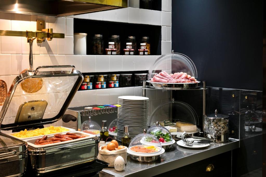 a kitchen with many dishes of food on a counter at Hôtel Square Louvois in Paris