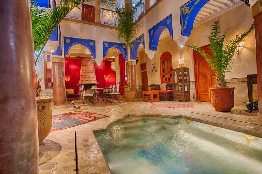 a home with a swimming pool in the middle of a room at Riad Kenzo in Marrakesh