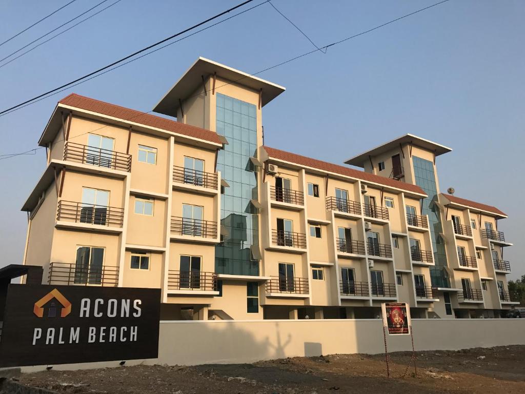 an apartment building with a sign in front of it at Acons Palm Beach in Alibaug