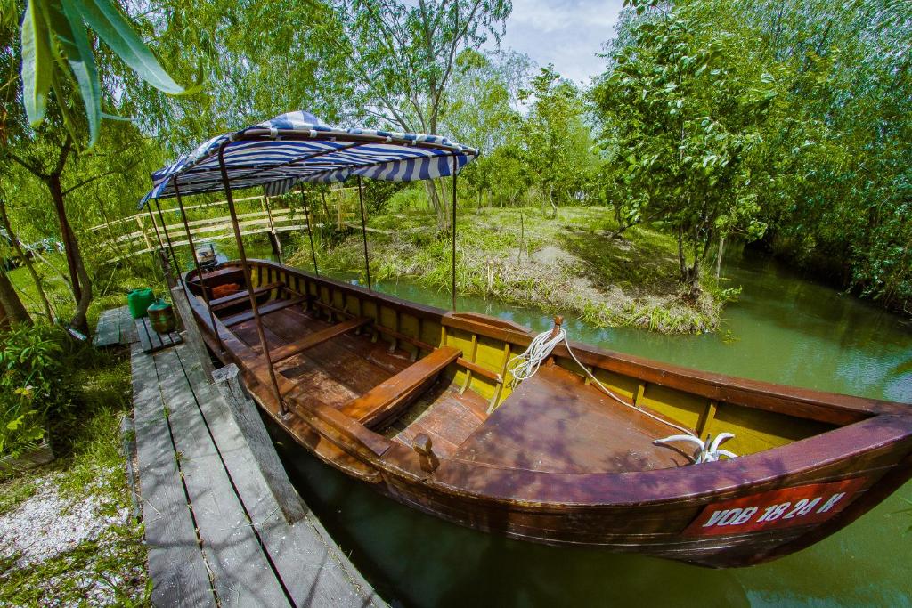 a wooden boat with an umbrella in the water at Dunaiskaya Usadba in Vylkove