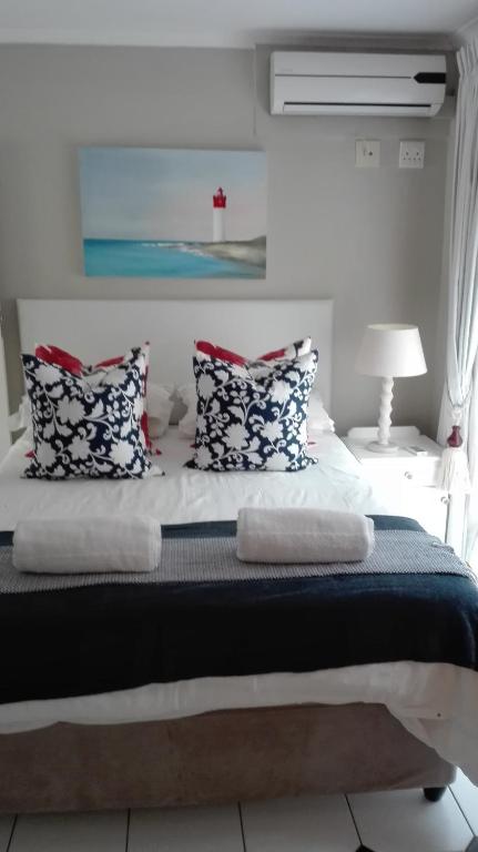 a bedroom with a large bed with pillows on it at 8A Oyster Crescent in Durban