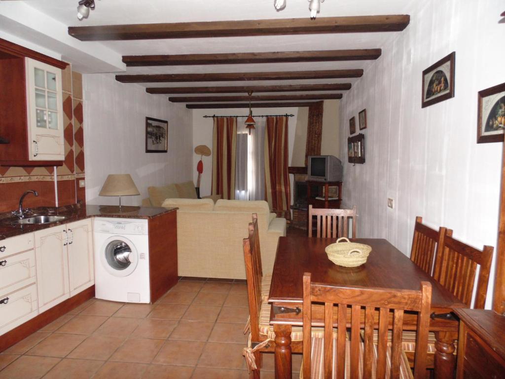 cocina y sala de estar con mesa de comedor y cocina en Apartamentos Rurales La Muralla II, en Cañete