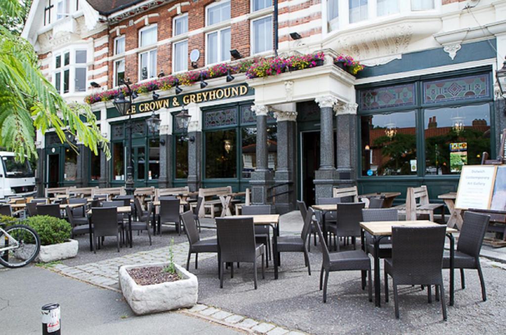 ein Restaurant mit Tischen und Stühlen vor einem Gebäude in der Unterkunft The Crown & Greyhound by Innkeeper's Collection in London