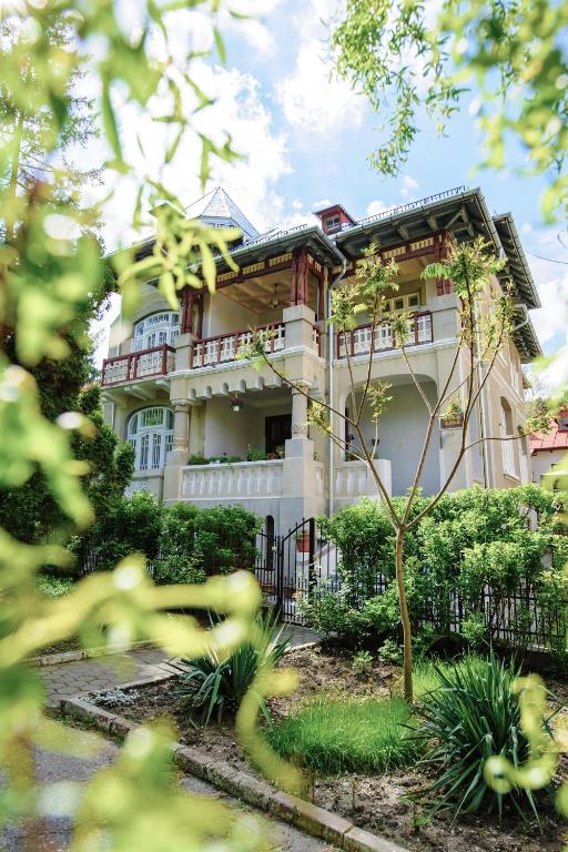 a large building with a fence in front of it at Vila Lili in Băile Govora