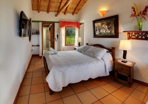 a bedroom with a large bed in a room at Hotel Spa Villa Lina in Villa de Leyva