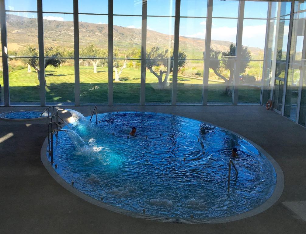 a large swimming pool in a building with a large window at Hotel Balneario de Gravalos in Grávalos