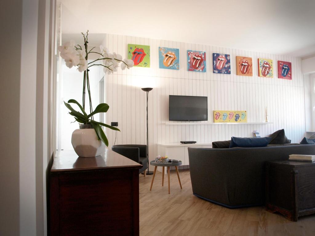 uma sala de estar com um sofá e um vaso de flores em Settimo Piano em La Spezia