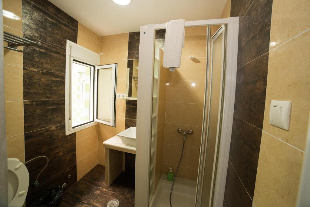 ein Bad mit einer Dusche, einem WC und einem Waschbecken in der Unterkunft Hospedaje Lisboa Algeciras in Algeciras
