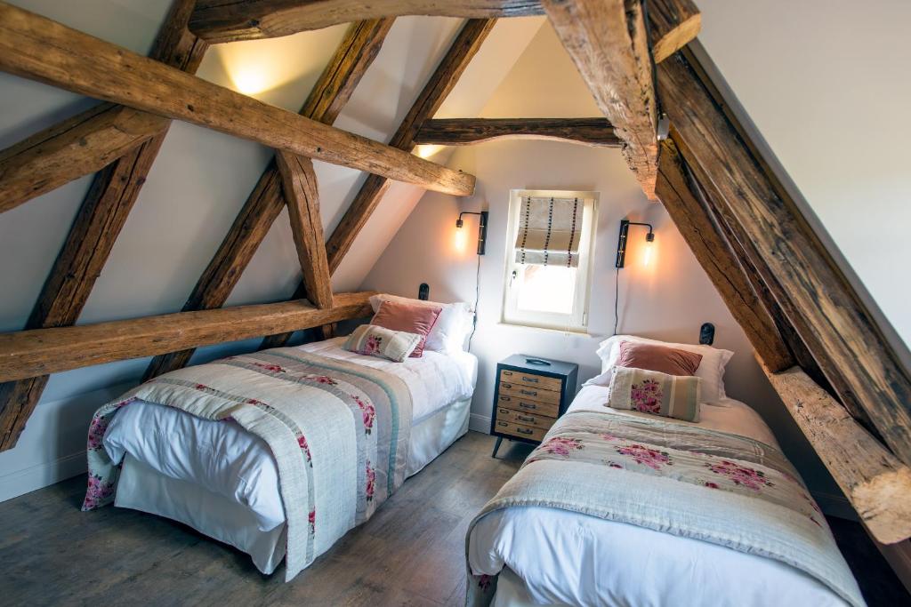 two beds in a attic room with wooden beams at Le B. VINTAGE in Riquewihr