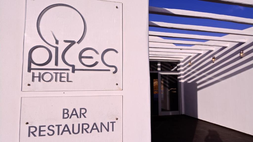 un cartello per un bar-ristorante accanto a una sala bar di Rizes Hotel a Livadakia