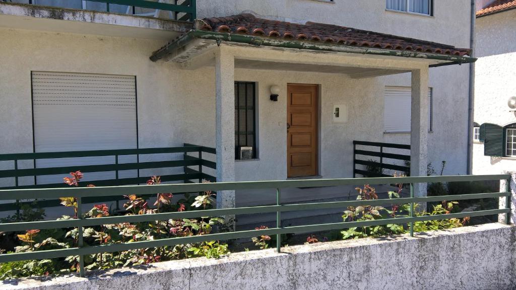une maison avec une clôture verte et quelques fleurs dans l'établissement Casa de Campo São Bernardo, à Penalva do Castelo