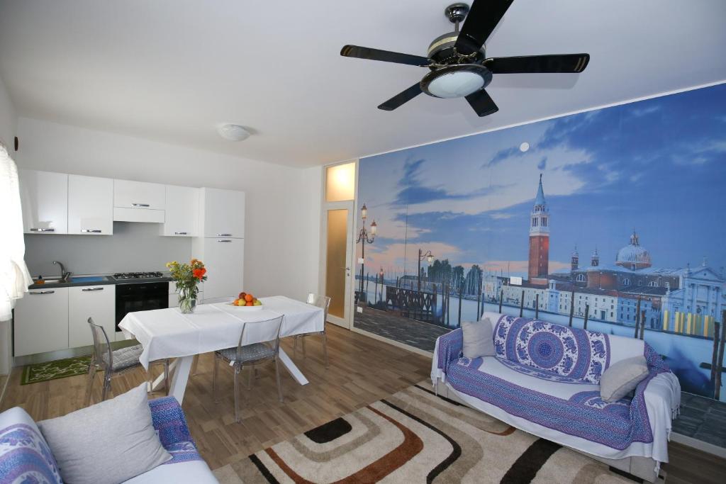 uma sala de estar com uma mesa e uma ventoinha de tecto em Venice Loft em Marghera