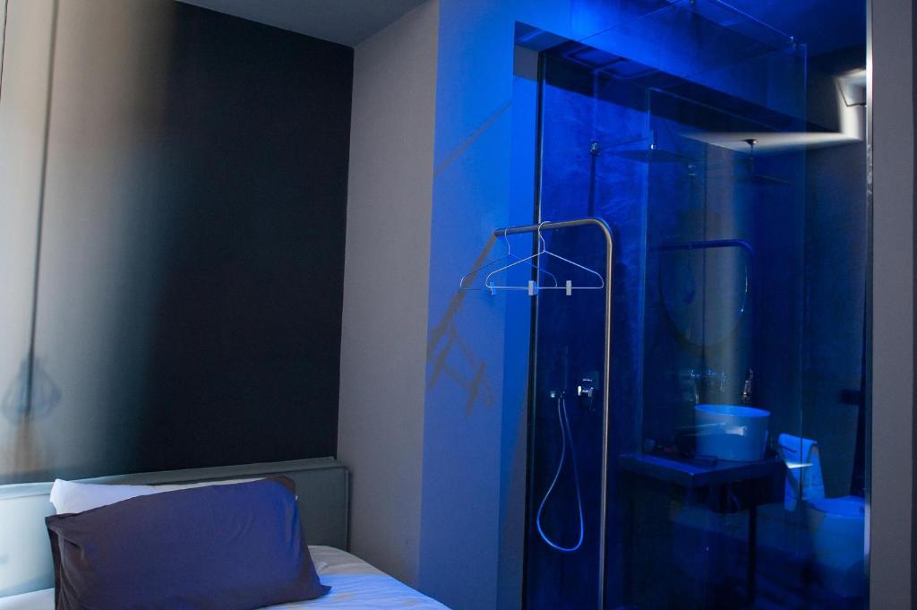 uma casa de banho com um chuveiro e uma parede azul em Dimora Villareale em Palermo