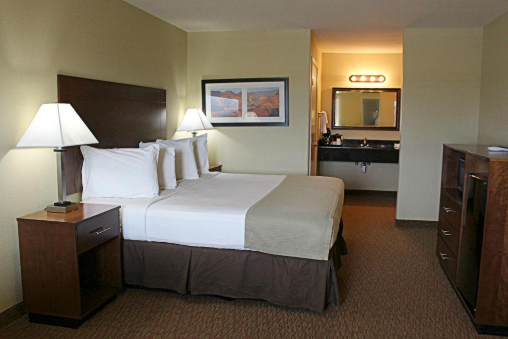 a hotel room with a large bed and a bathroom at Southern Inn and Suites Kermit in Kermit
