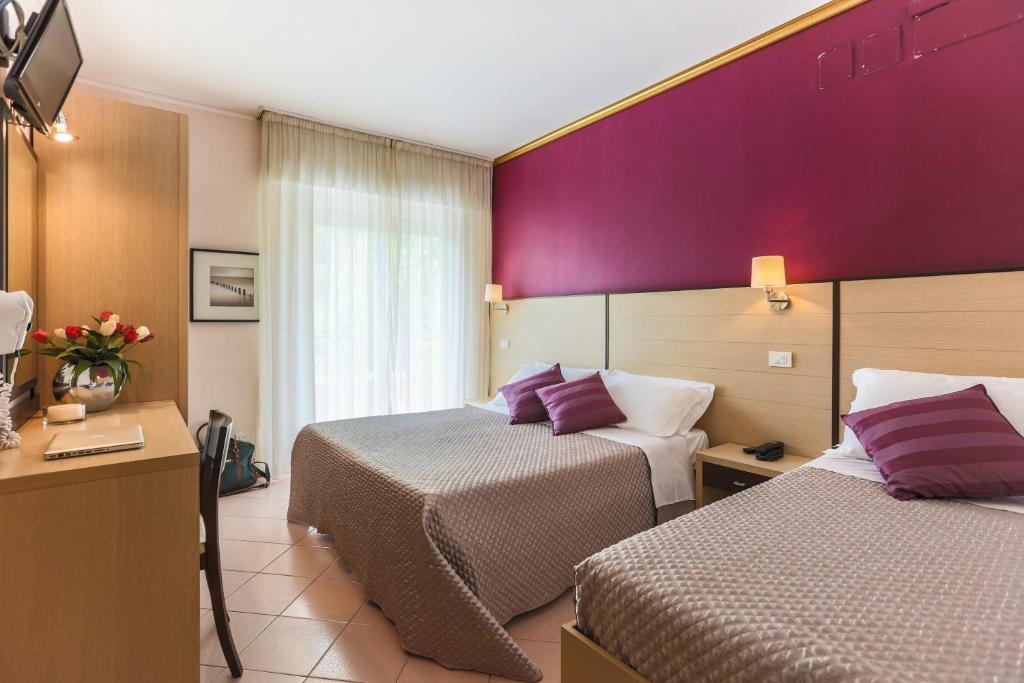 リッチョーネにあるHotel Aldebaranの紫の壁のホテルルーム