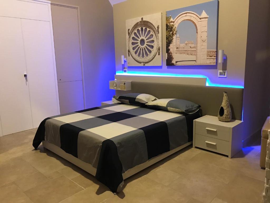 トラーニにあるOroVerde B&Bのベッドルーム(青色の照明付きの白黒ベッド1台付)
