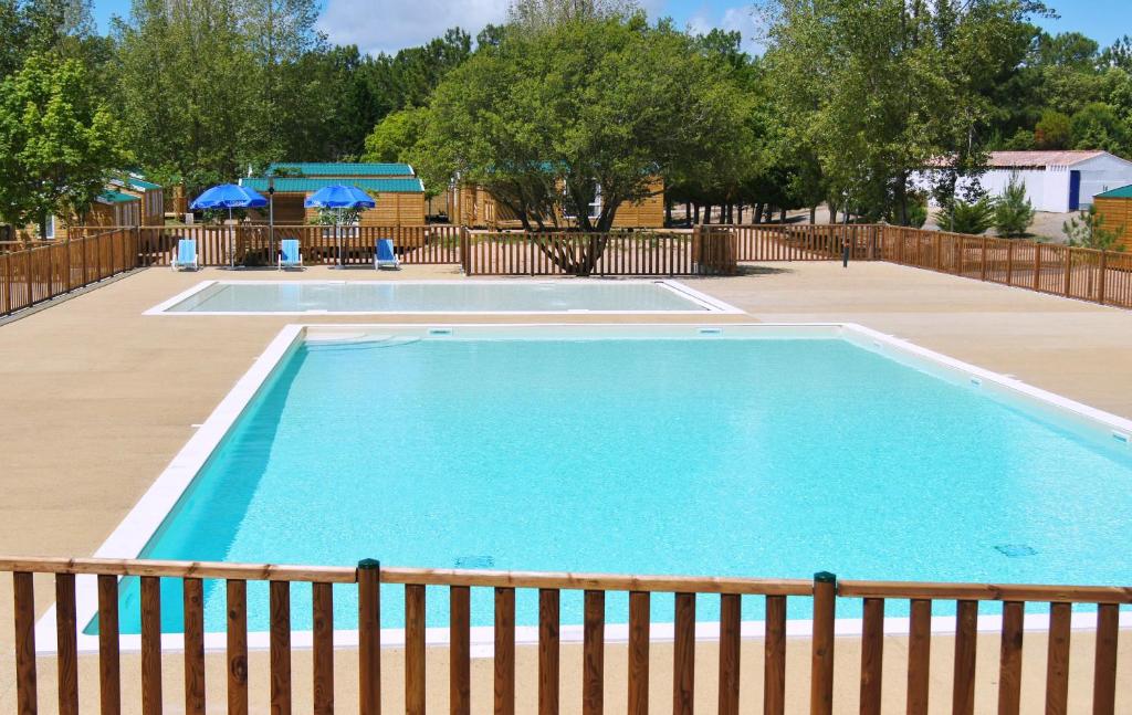 una gran piscina con una valla alrededor en Domaine Résidentiel de Plein Air Odalys Les Demoiselles en Saint-Hilaire-de-Riez