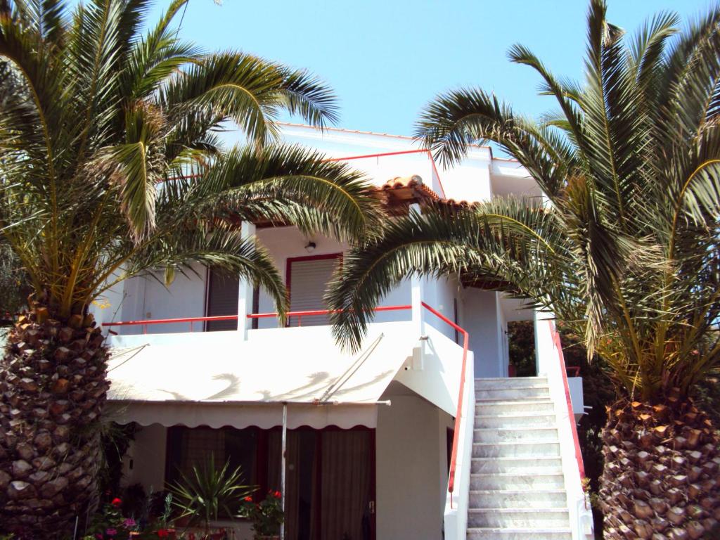 una casa blanca con palmeras delante en Irini Studios, en Plomari
