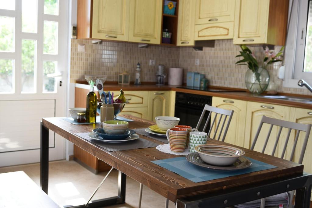 una cocina con una mesa de madera con platos. en Dimitris' & Valentina's Home en Plakiás