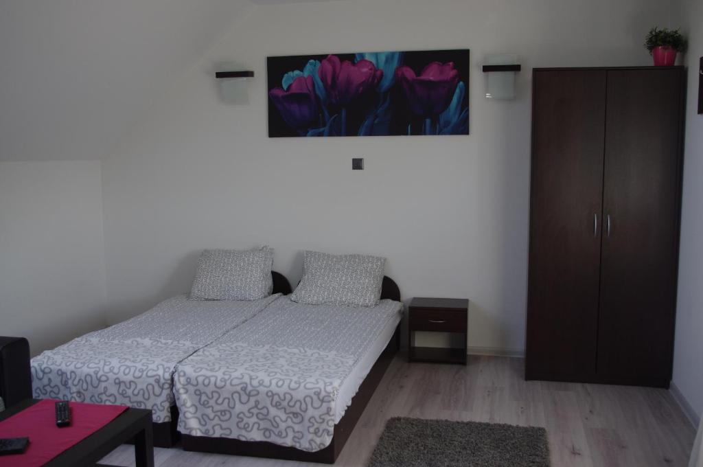 1 dormitorio con 1 cama y una pintura en la pared en Monique, en Wrzosowo