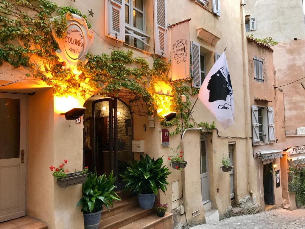 un edificio con piante in vaso sul lato di COLOMBA Hôtel Restaurant a Bonifacio