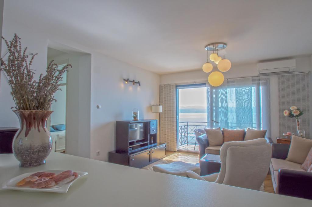 uma cozinha e sala de estar com um vaso de flores sobre uma mesa em Apartment Ranch em Opatija