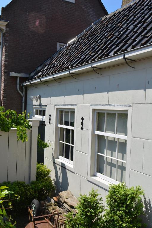 Una casa blanca con dos ventanas en el lateral. en Waterland Vakantiehuis, en Monnickendam