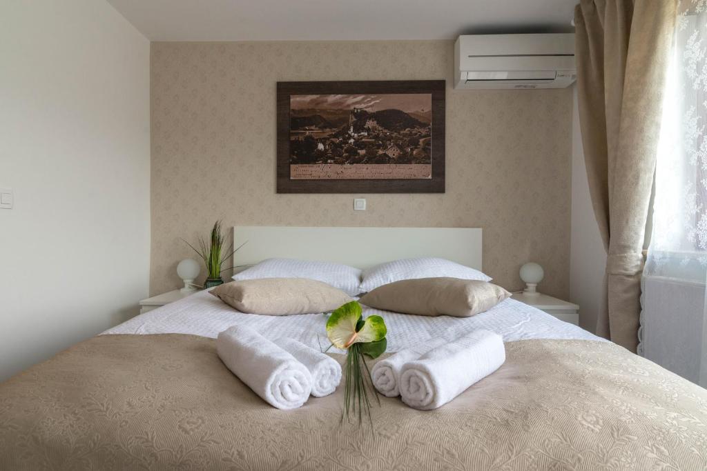 - une chambre avec un lit blanc et des serviettes dans l'établissement Apartments & Rooms Aleksandra, à Bled