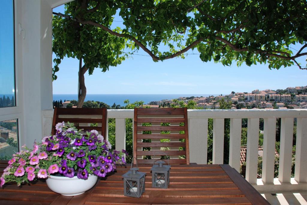 een veranda met twee vazen bloemen op een tafel bij Luigi apartments in Dubrovnik