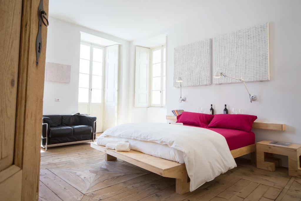 1 dormitorio con 1 cama grande con almohadas rojas en winebnb, en Sondrio