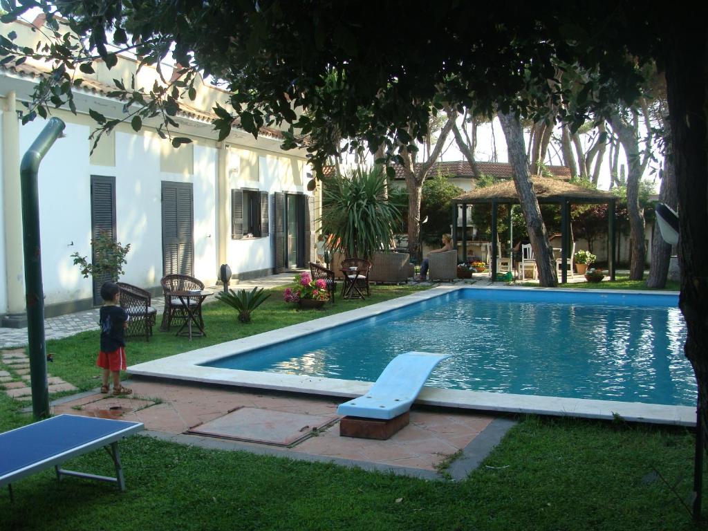 a child standing in front of a swimming pool at Villa Elena spiaggia a 100m in Baia Domizia